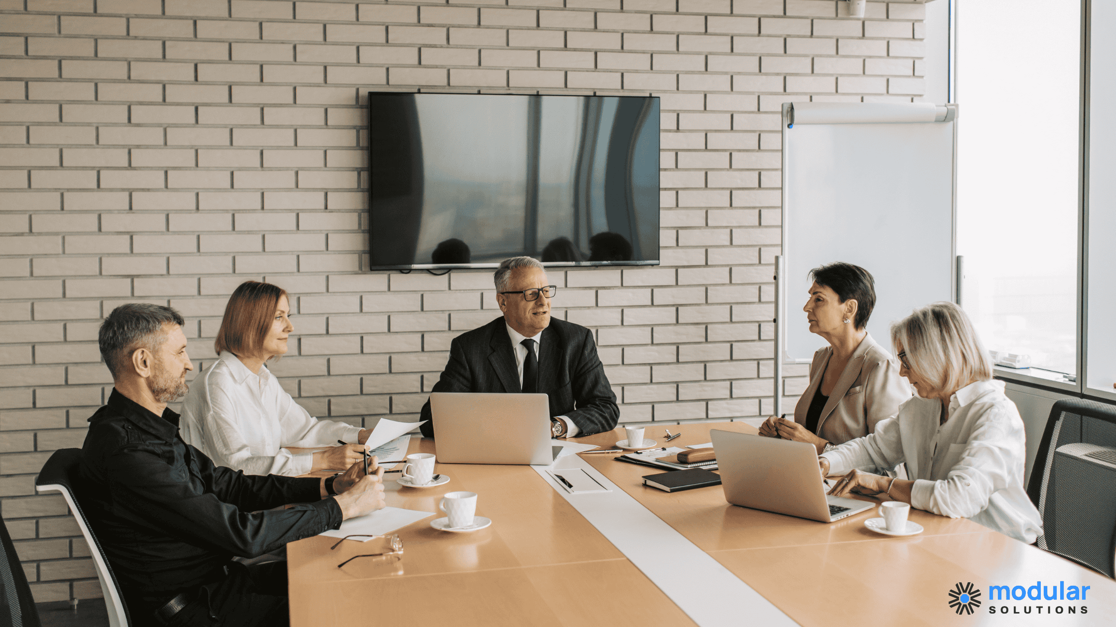 Boardroom discussing build vs buy for insurance software